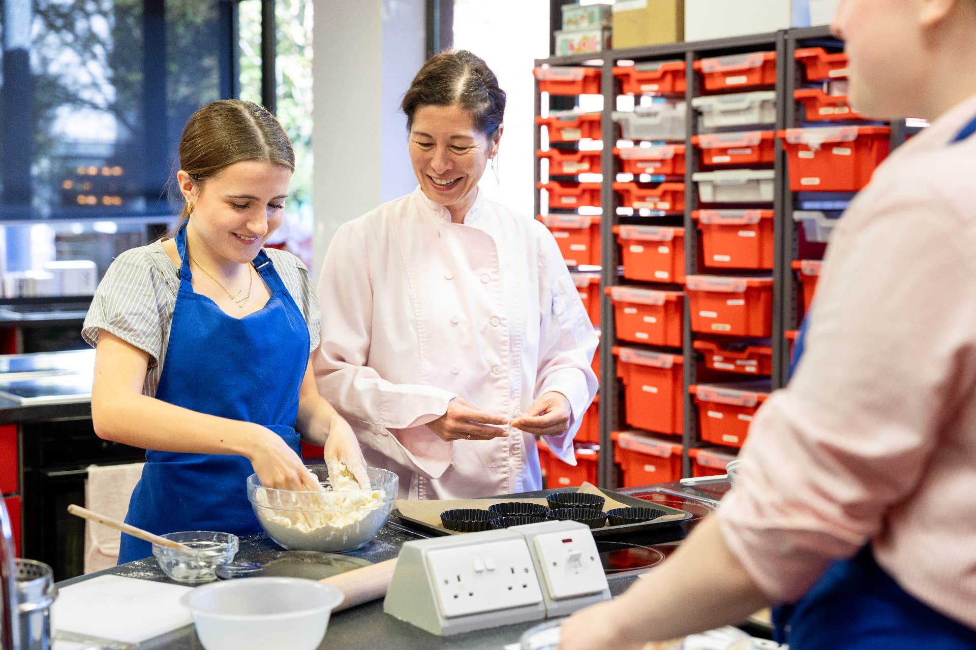 A Food Science student receiving practical guidance in the kitchen